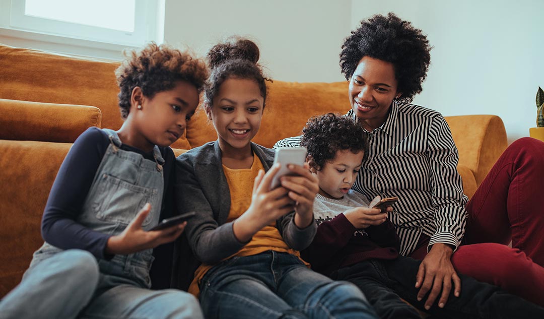 Mother and children looking at smartphones