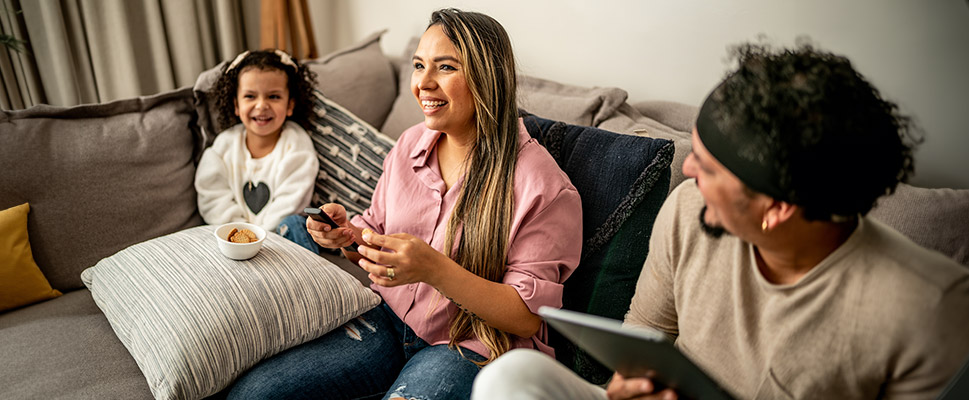 Family watching TV and using laptop