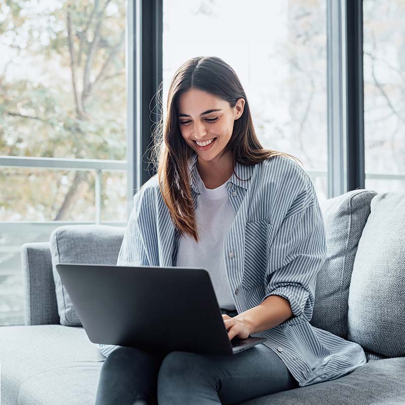 Woman using laptop by window